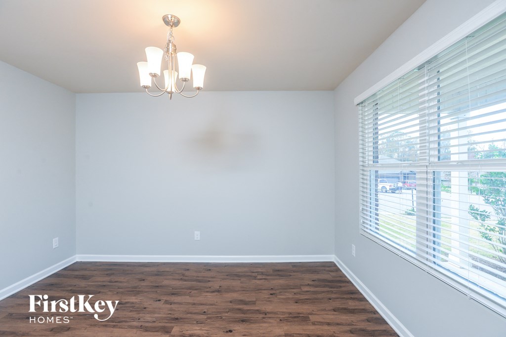 an empty room with a large window and a chandelier