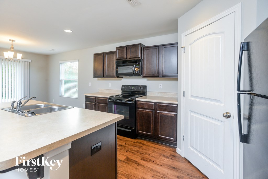 a kitchen with dark wood cabinets and a white door