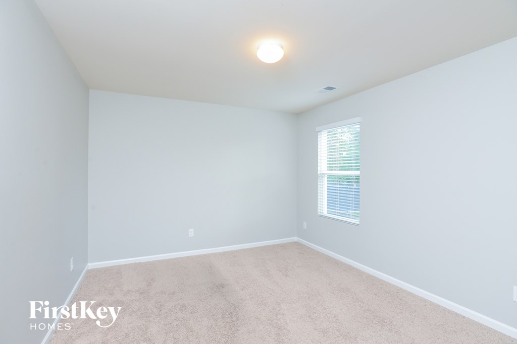 a bedroom with a carpeted floor and a window