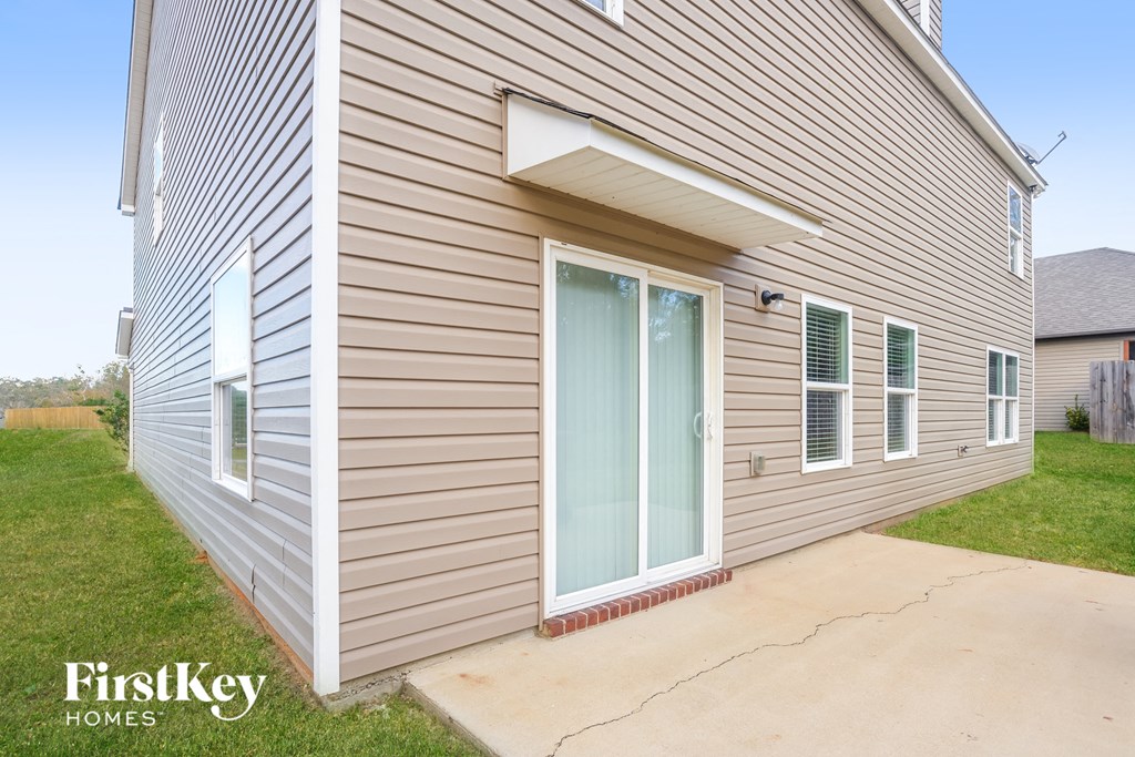 the outside of a house with a patio and a glass door