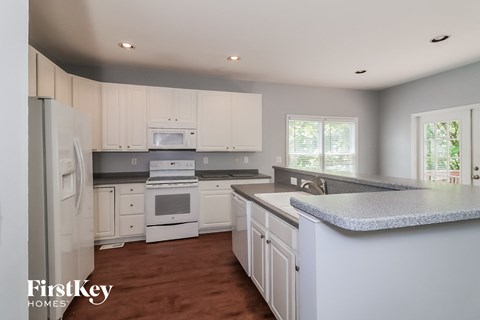 a white kitchen with white cabinets and white appliances