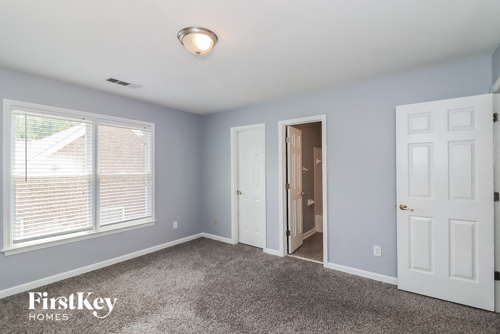 a bedroom with blue walls and white doors and a carpeted floor