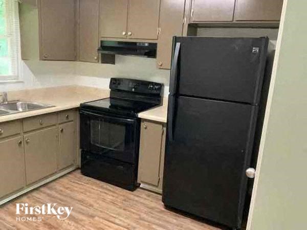 a kitchen with a black refrigerator and a stove
