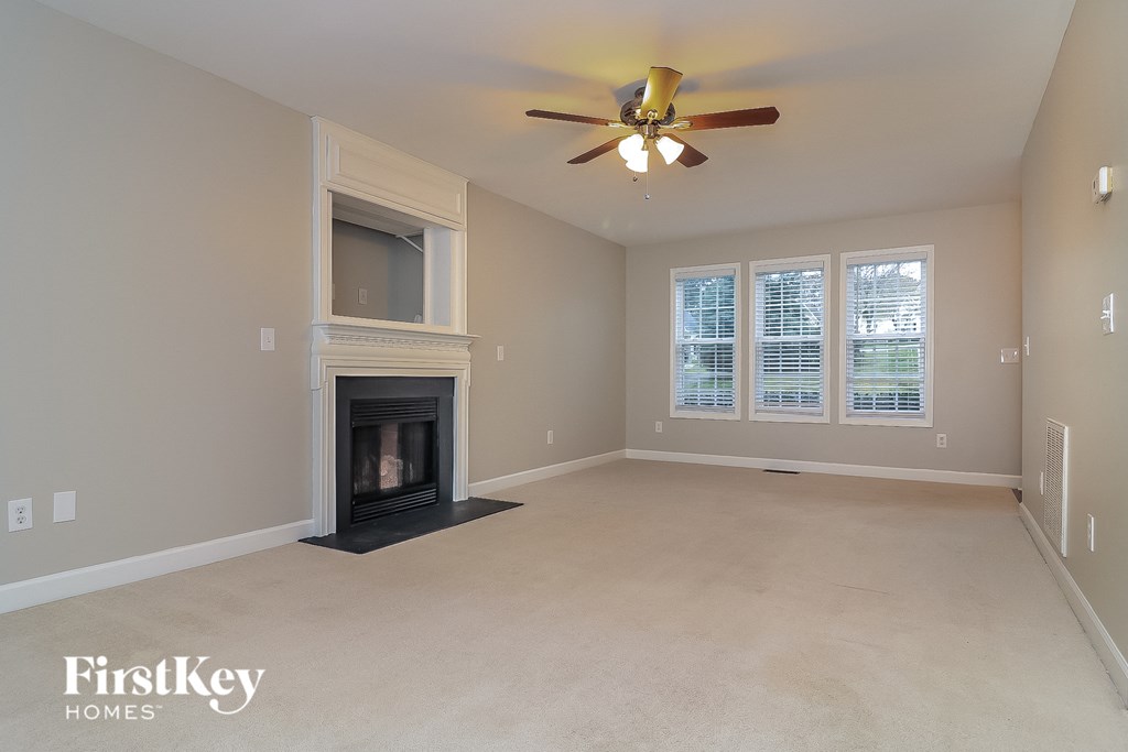 a living room with a fireplace and a ceiling fan