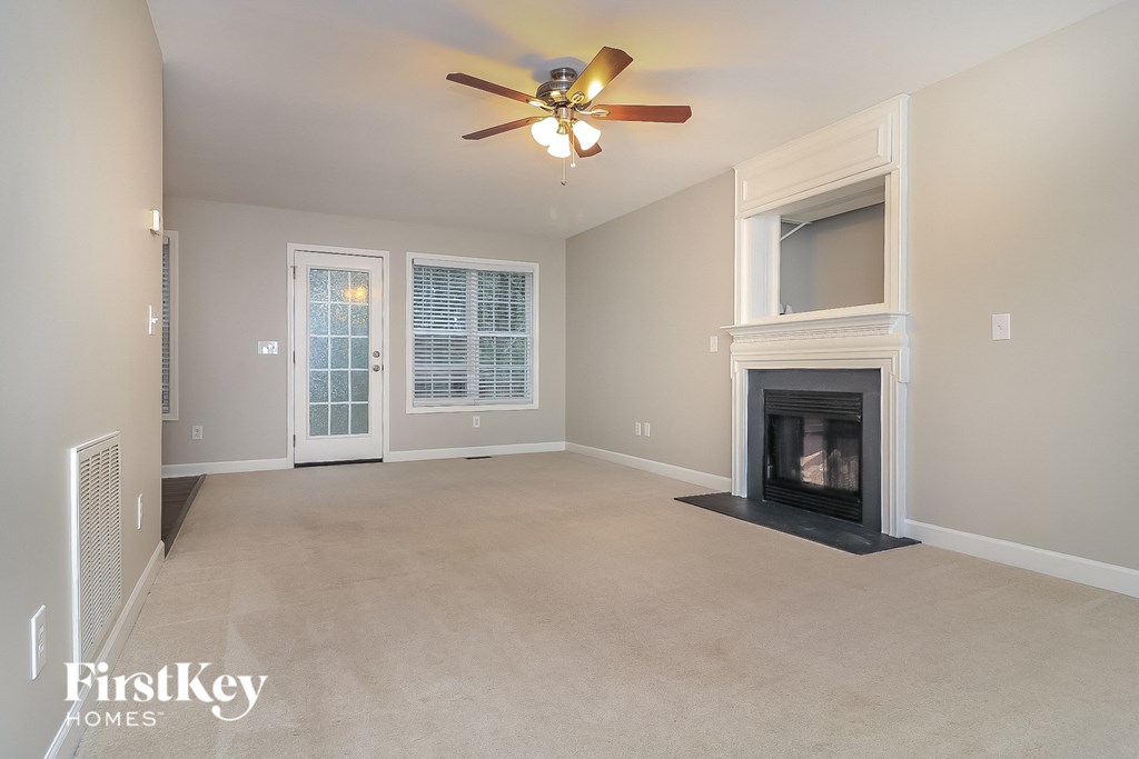 a living room with a fireplace and a ceiling fan