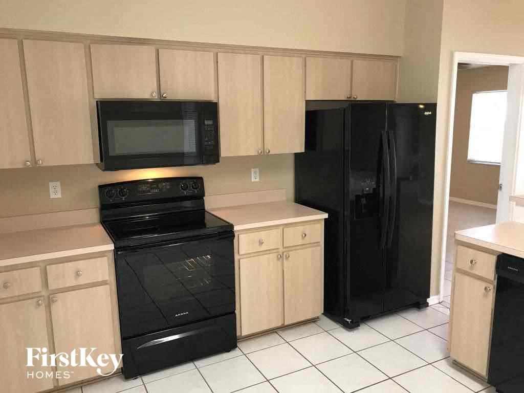 a kitchen with black appliances and wooden cabinets