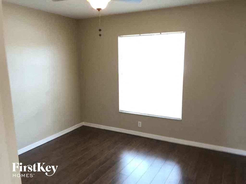 an empty living room with a window and wooden floors