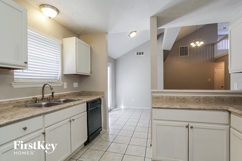 A kitchen with white cabinets and a sink.