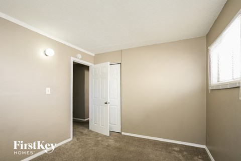a bedroom with a door to a closet and a window