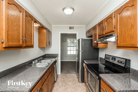 A kitchen with wooden cabinets and a black stove top oven.