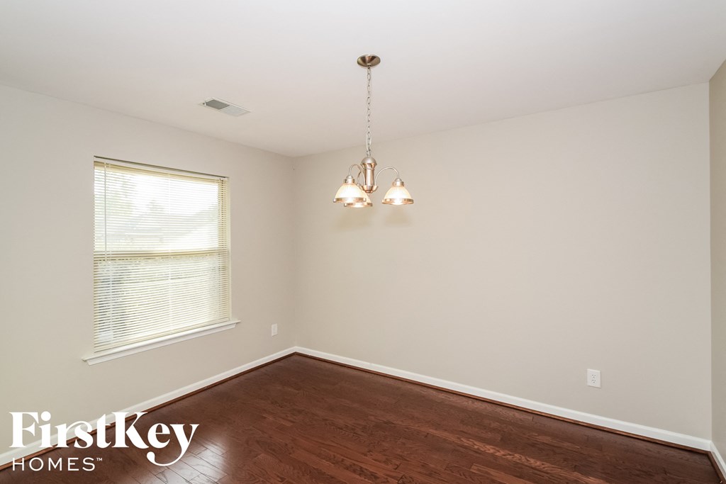 a bedroom with a wood floor and a window and a chandelier