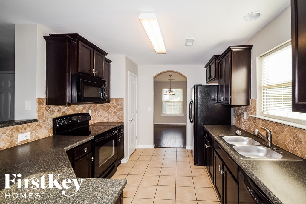 a kitchen with black appliances and granite counter tops