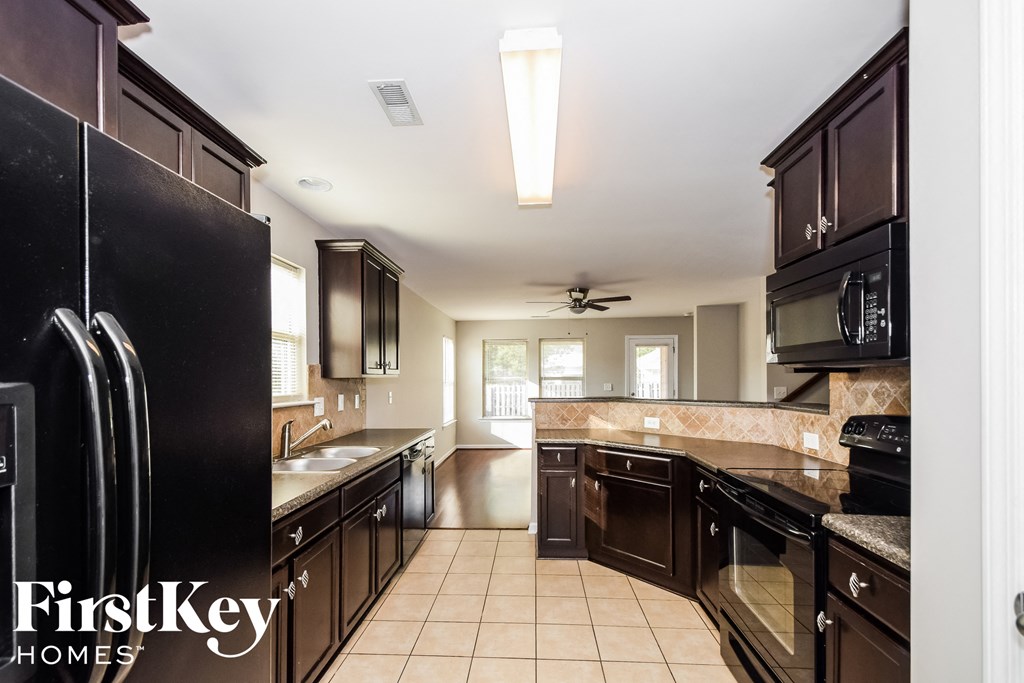 a large kitchen with black appliances and granite counter tops