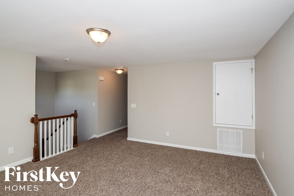 the upstairs bonus room has carpeted floors and a staircase