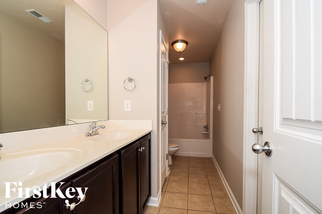 a bathroom with a large mirror and a sink and a toilet