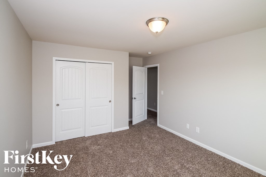 a bedroom with two closets and a carpeted floor