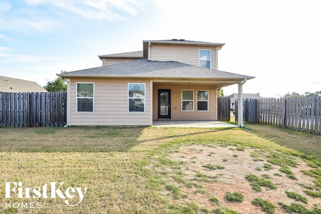 a small house with a yard and a fence