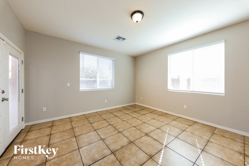 A room with a tiled floor and a window with blinds.
