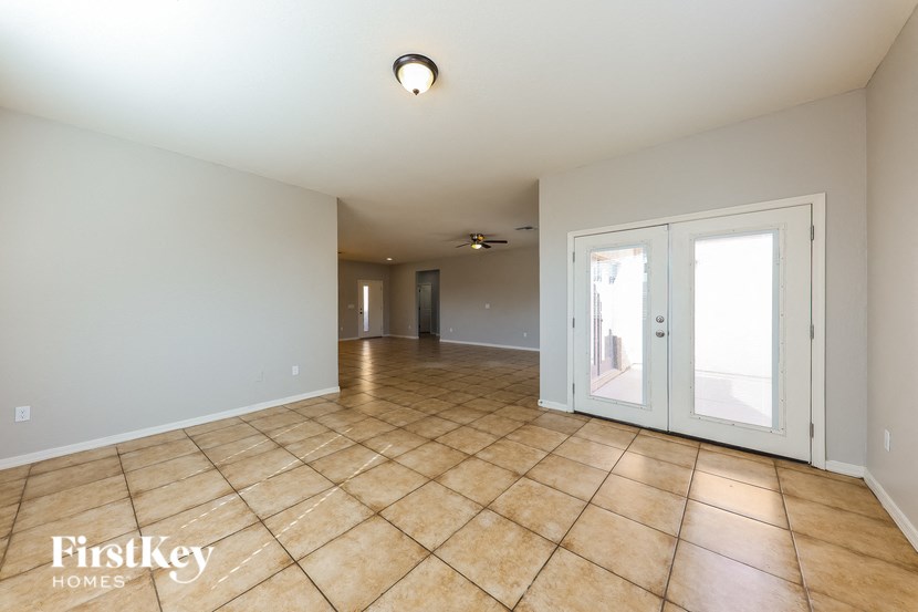 A spacious room with tile flooring and white walls.