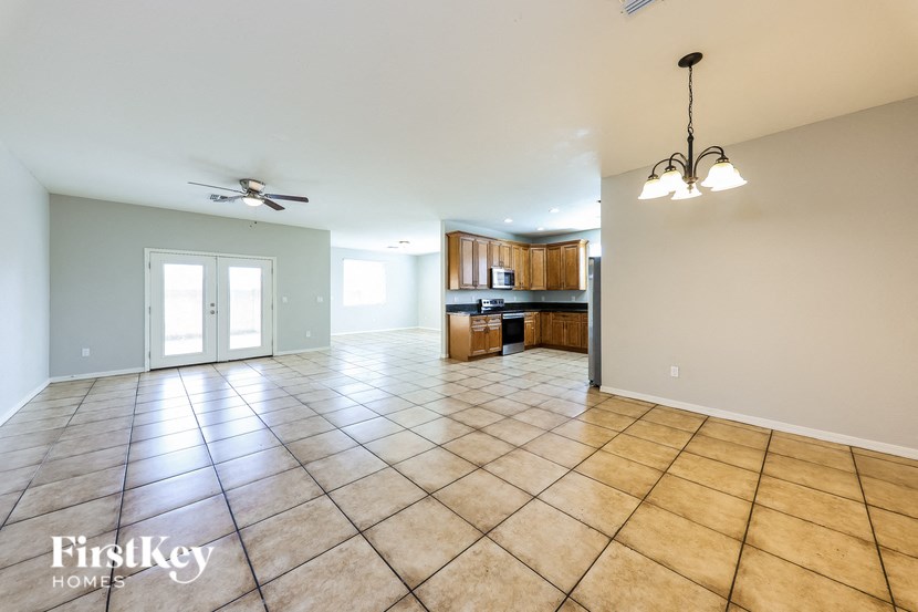 A spacious room with tile flooring and a ceiling fan.