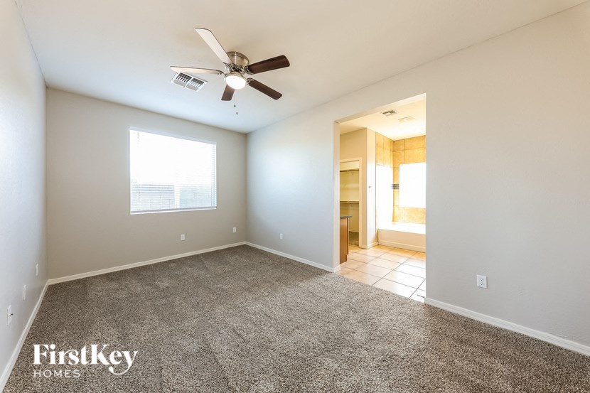 A spacious room with a ceiling fan and a window.