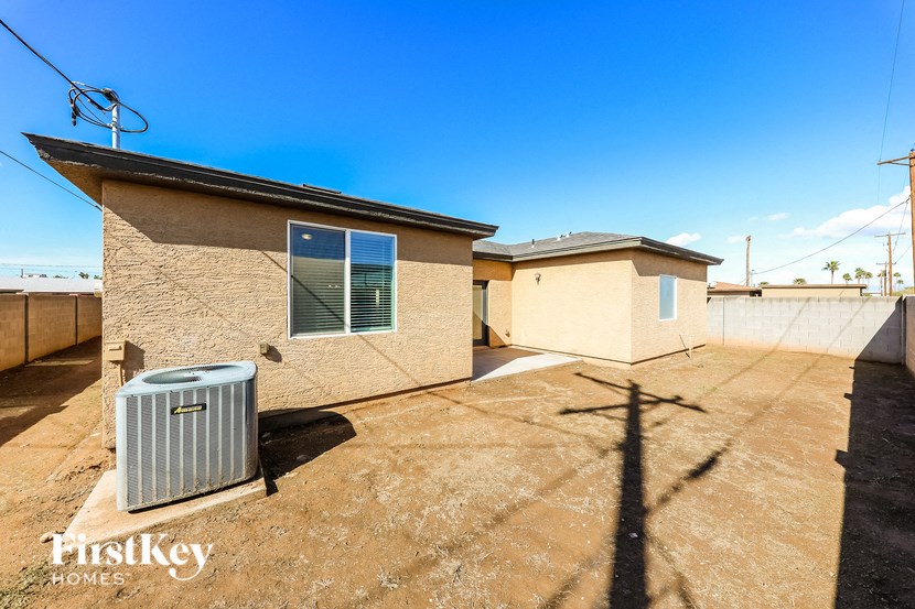 A house with a brown roof and tan walls is for sale.