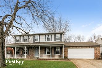 a white and brick house with a white garage door