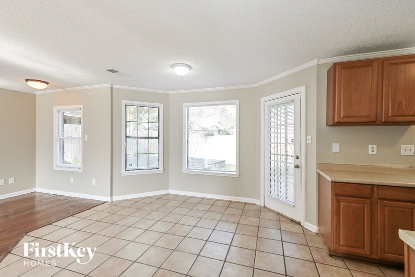 an empty living room with cabinets and a kitchen