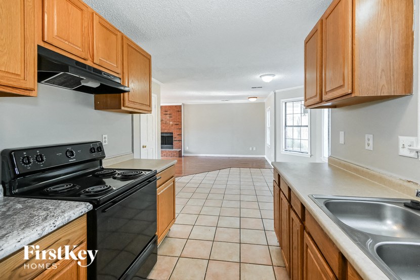 a kitchen with wooden cabinets and a stove and a sink