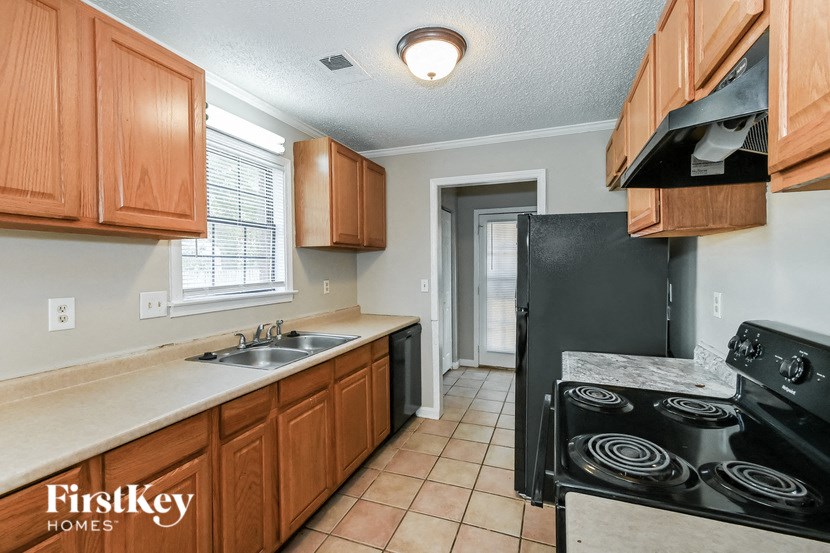 a kitchen with a stove and a sink and a refrigerator