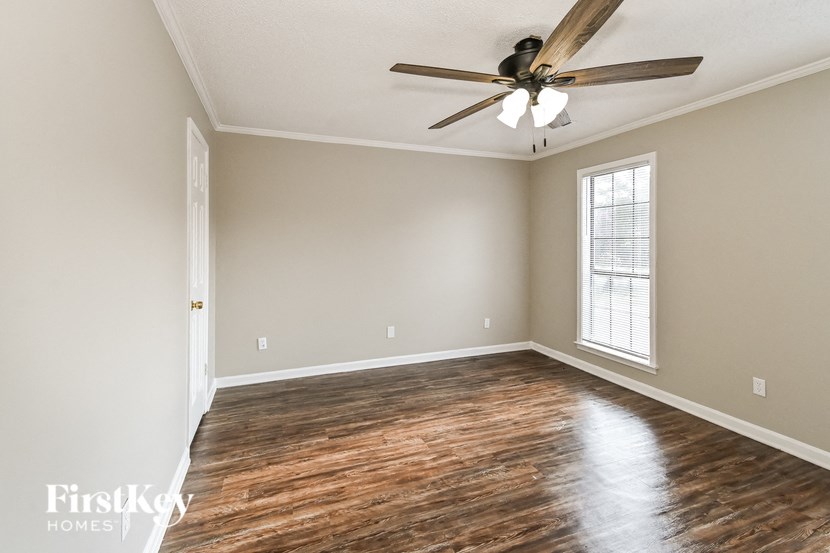 an empty room with a ceiling fan and a window