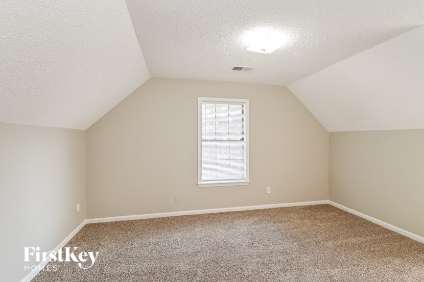 a spacious room with carpet and a window
