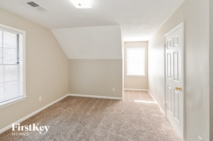 an empty room with a white door and a window