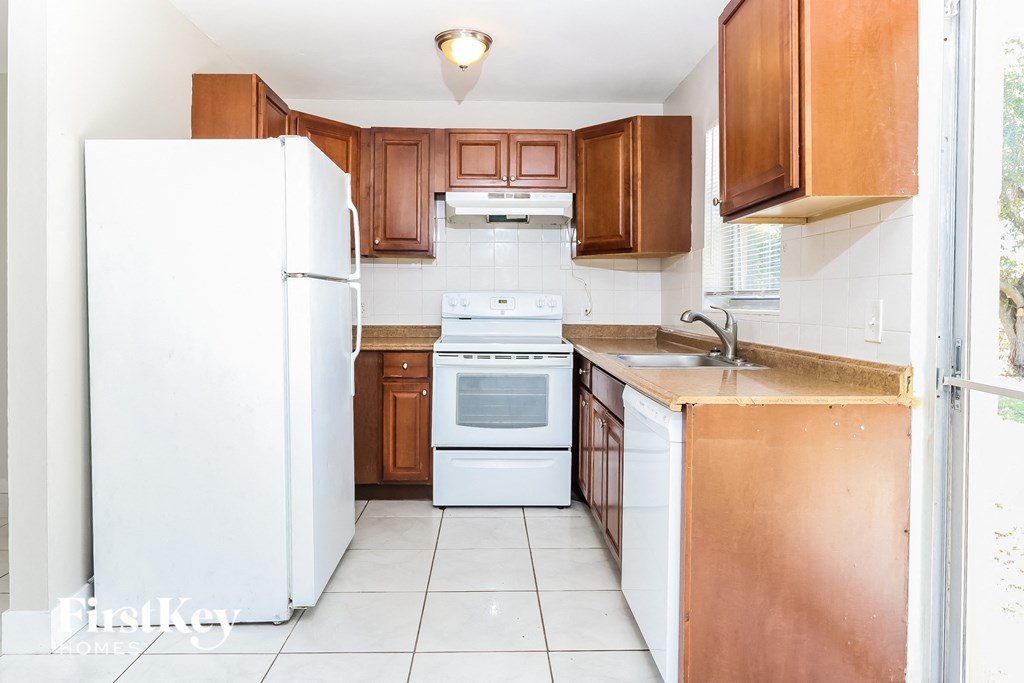 a small kitchen with white appliances and wooden cabinets