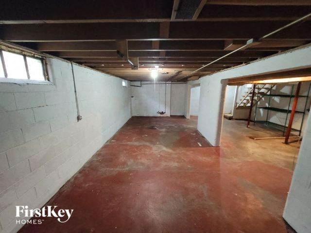an empty basement with a red floor and white walls