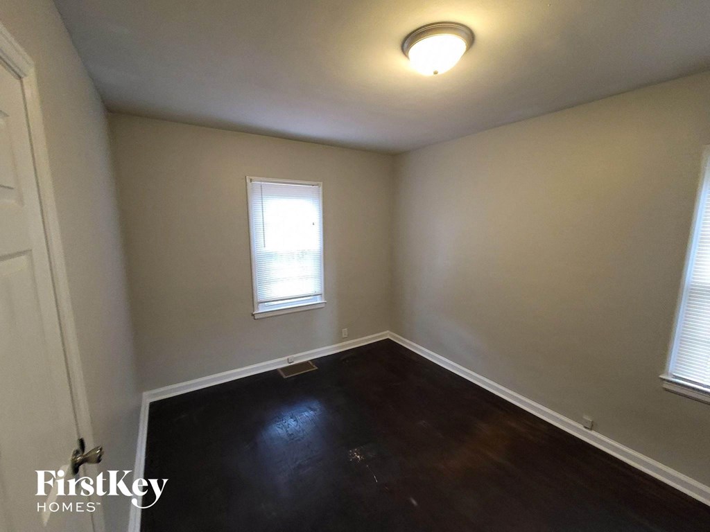 a empty room with wooden floors and a window