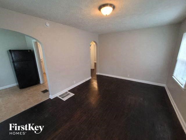an empty living room with white walls and wood floors