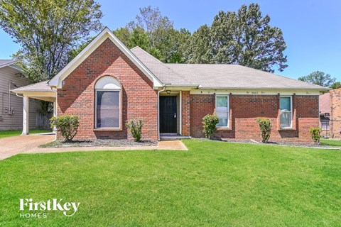 a brick house with a lawn in front of it