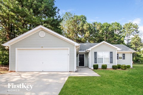 a white house with a white garage door and a lawn