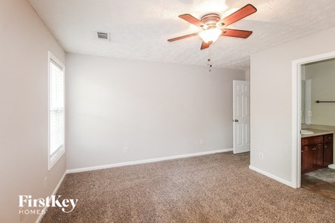 a bedroom with a ceiling fan and a bathroom
