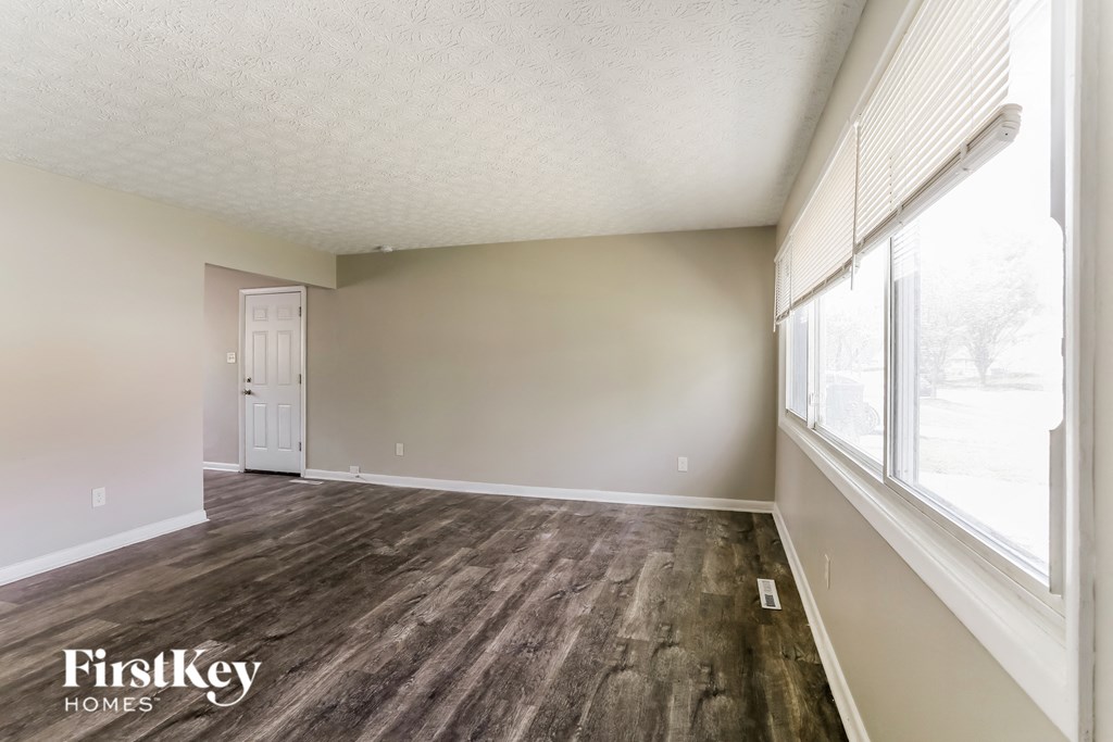 a living room with wood flooring and a large window