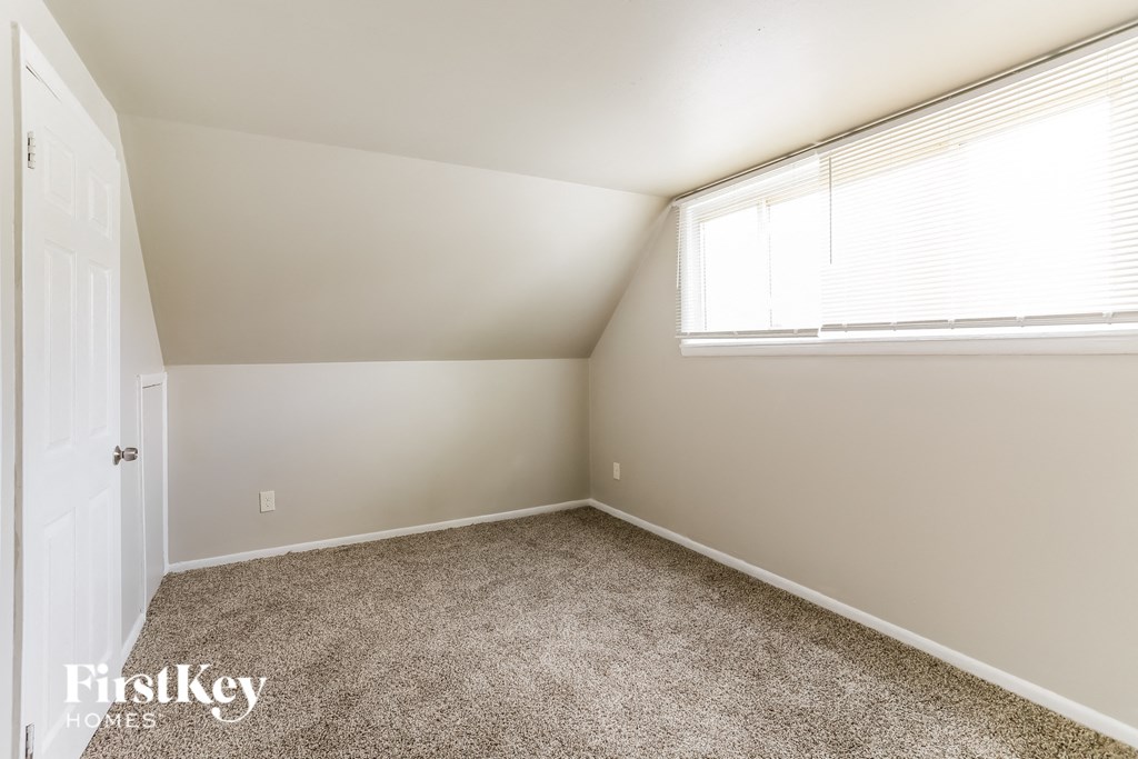 a bedroom with a carpeted floor and a window