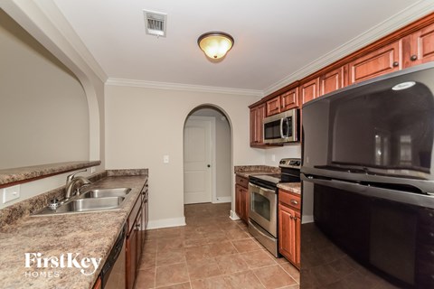a kitchen with granite counter tops and black appliances