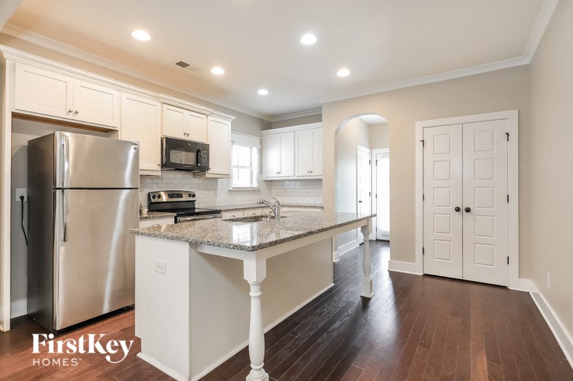 a kitchen with white cabinets and a granite counter top