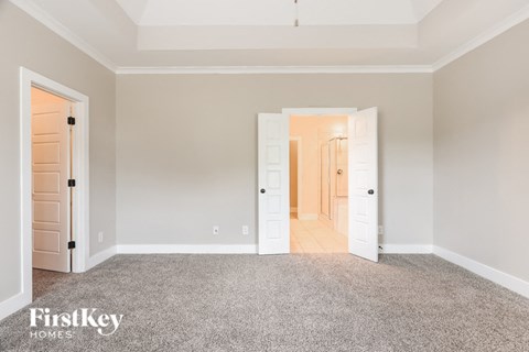 a master bedroom with a carpeted floor and white doors
