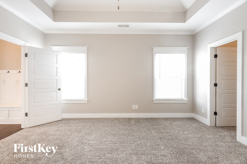 a empty room with two white doors and a carpeted floor