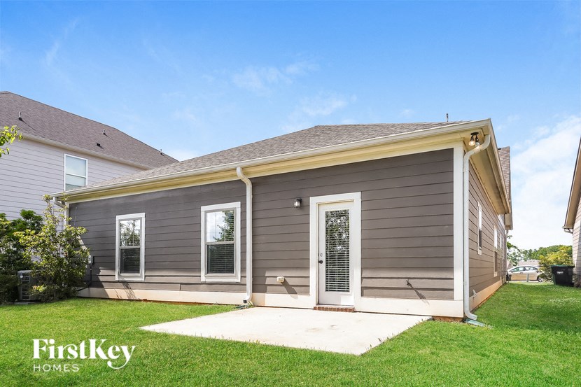 the front of a house with a porch and a lawn