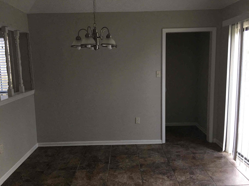 A room with a tiled floor and a chandelier hanging from the ceiling.