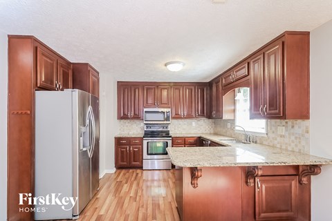 a kitchen with wooden cabinets and stainless steel appliances and a marble counter top