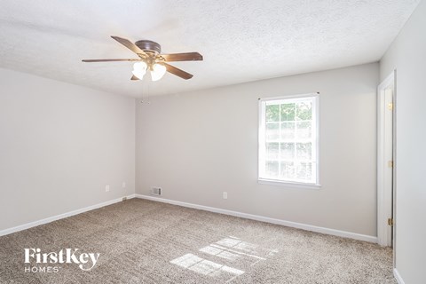 a bedroom with carpet and a ceiling fan